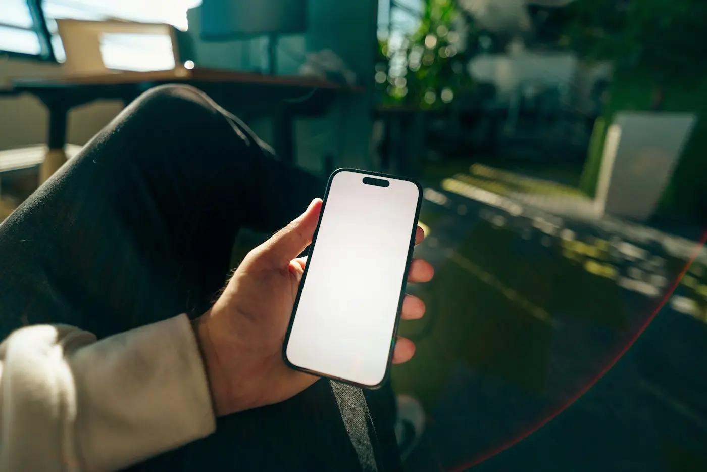 Una mano sostiene un celular con la pantalla encendida
